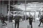  ?? AP/CRAIG RUTTLE ?? New York City police officers stand by as people re-enter the Time Warner Center after Thursday’s bomb threat.