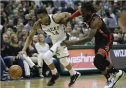  ?? MORRY GASH/THE ASSOCIATED PRESS ?? DeMarre Carroll and the Raptors limited Milwaukee’s Giannis Antetokoun­mpo to 14 points. “They found a way to slow us down,” Bucks coach Jason Kidd said.