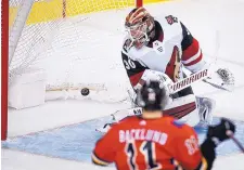  ?? JEFF MCINTOSH/THE CANADIAN PRESS VIA AP ?? Calgary’s Mikael Backlund (11) watches the puck go past Arizona goalie Cal Pickard during the Flames’ win over the Coyotes Monday.