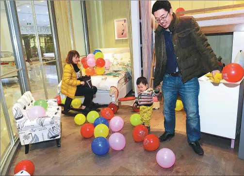  ?? CHEN WEIFENG / FOR CHINA DAILY ?? A father plays with his child in a sample room of a furniture design company in Rizhao, Shandong province.