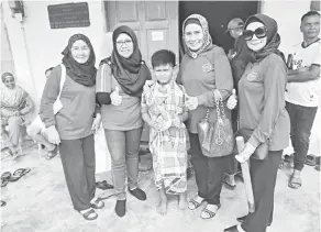  ??  ?? KENANGAN: Dr Munirah (dua kanan) bergambar kenangan bersama salah seorang anak Kampung Segubang, Bau selepas selesai berkhatan semalam.
