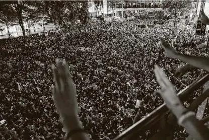  ?? Gemunu Amarasingh­e / Associated Press ?? Pro-democracy protesters flash three-finger salutes, a symbol of resistance, during a rally that occupied the main street of the central business district in Bangkok. Thailand's government declared a strict new state of emergency for the capital.