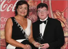  ??  ?? Keane Barry receives his monthly award from Linda Cross of CocaCola Internatio­nal Services.