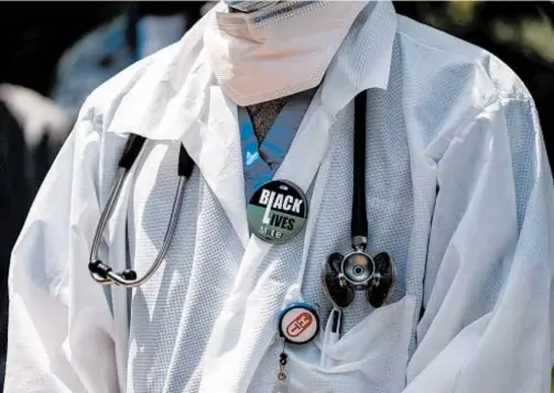  ?? DAVID DEE DELGADO/GETTY ?? Health care workers show solidarity with the Black Lives Matter movement in June in New York.