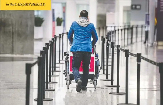  ?? PETER J THOMPSON / POSTMEDIA NEWS ?? A traveller walks through Toronto's Pearson airport on Wednesday. Police say some internatio­nal travellers arriving at the airport are refusing to check into quarantine hotels.