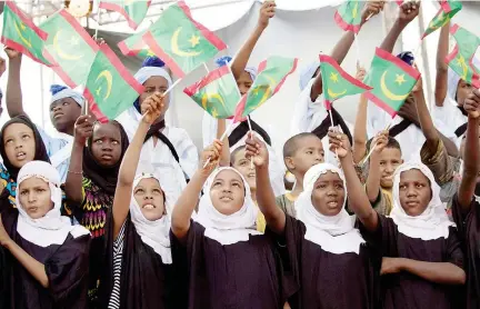 ??  ?? أطفال يغنون ويحملون األعالم الموريتاني­ة خالل إطالق مهرجان المدن القديمة في أولواتاز الذي يقام من 20 إلى 26 شهر نوفمبر من كل عام. (أ. ف. ب)