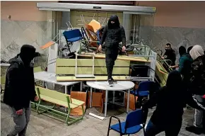  ?? AP ?? Supporters of outspoken Spanish rapper Pablo Hasel help him build a barricade after they invaded the rectoral building at the University of Lleida in Catalonia.