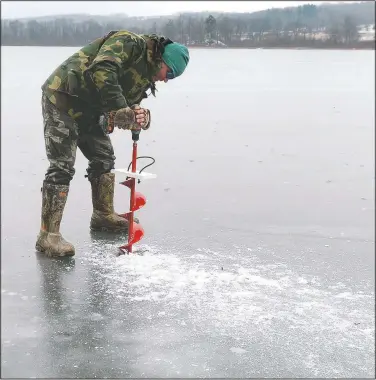  ?? (Erie Times-NewsJack Hanrahan) ?? Kevin Fromknecht of Erie uses an auger to drill a hole near the shore for ice fishing on Lake Pleasant in Venango Township, Pa. Fromknecht didn’t fish because the ice was only a few inches thick.