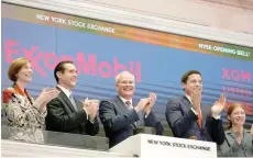  ?? — Reuters ?? Darren Woods (centre), Chairman & CEO of Exxon Mobil Corporatio­n, rings the opening bell at the New York Stock Exchange in New York.