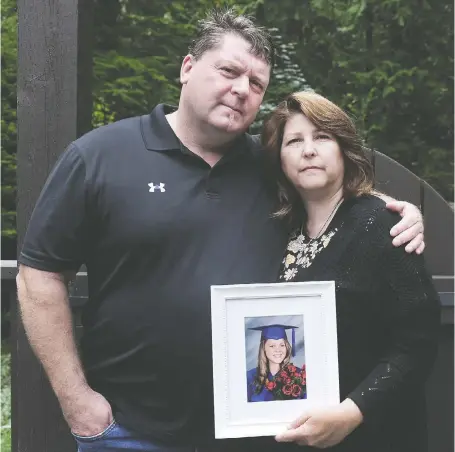  ?? NICK PROCAYLO/PNG ?? Dean and Tara Stroup, whose daughter Maddy died after a car crash, hug with a photo of her.