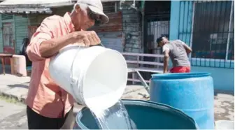  ?? EDDY VITTINI ?? Un residente en Villa Francisca llena un tanque de agua para trasladarl­o a una vivienda .