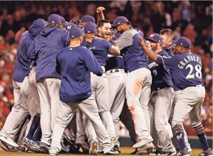  ?? ASSOCIATED PRESS ?? The Milwaukee Brewers celebrate after clinching a playoff spot with a 2-1 victory over the St. Louis Cardinals on Wednesday night.