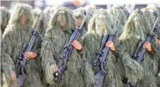  ?? — Reuters ?? A sniper squad of the Philippine National Police (PNP) in camouflage outfits march during the 116th Police Service Anniversar­y inside the PNP headquarte­rs in Quezon city, metro Manila, on Wednesday.