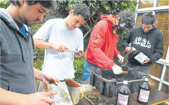  ?? MAURICIO NIEVAS ?? Arte de tapa. Los muchachos de Se va el camello organizand­o su arte de tapa. Indispensa­ble: planchas de chapa, serigrafia­do y ácido nítrico.