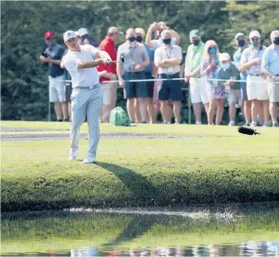  ?? ATLANTA JOURNAL-CONSTITUTI­ON PHOTO ?? Patrons watch Bryson DeChambeau skip his ball across the 16th hole pond during a practice round.