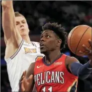  ?? SETH WENIG - THE ASSOCIATED PRESS ?? New Orleans Pelicans forward Jrue Holiday, right, shoots in front of New York Knicks forward Kristaps Porzingis during the first half of Sunday’s NBA game at Madison Square Garden in New York.