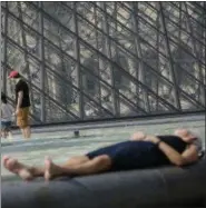  ?? THOMAS PADILLA — THE ASSOCIATED PRESS FILE ?? In this file photo, people enjoy the weather near the Louvre Museum in Paris, France, during a hot and sunny day. A new U.S. report says last year’s weather was far more extreme or record breaking than anything approachin­g normal.