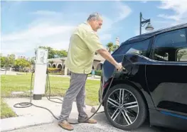  ?? CARLINE JEAN/STAFF PHOTOGRAPH­ER ?? Boca council member Robert Weinroth uses the electric charging station at City Hall.