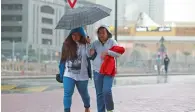  ?? Photo by Shihab ?? Two women share an umbrella as they cross the Sharjah-Dubai border on Sunday afternoon. —
