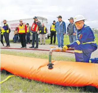  ?? GAVIN YOUNG ?? Emergency managers and public works profession­als get a demonstrat­ion of a Tiger Dam at a flood readiness orientatio­n Monday at the High River Rodeo Grounds.