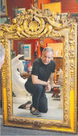  ?? Picture: GLENN HAMPSON ?? Antiques dealer Rodney Overton with a mirror which was once supposedly owned by Queen Victoria.