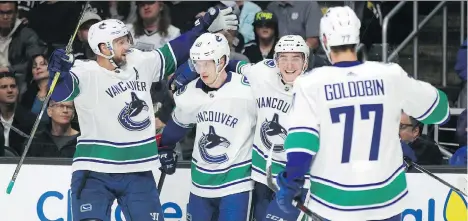  ?? JAE C. HONG/THE ASSOCIATED PRESS ?? Vancouver’s Alexander Edler, from left, Elias Pettersson, Jake Virtanen and Nikolay Goldobin react to a goal by Pettersson on Saturday in Los Angeles. The Canucks won 4-2 for their first victory since beating Boston 8-5 on Nov. 8.