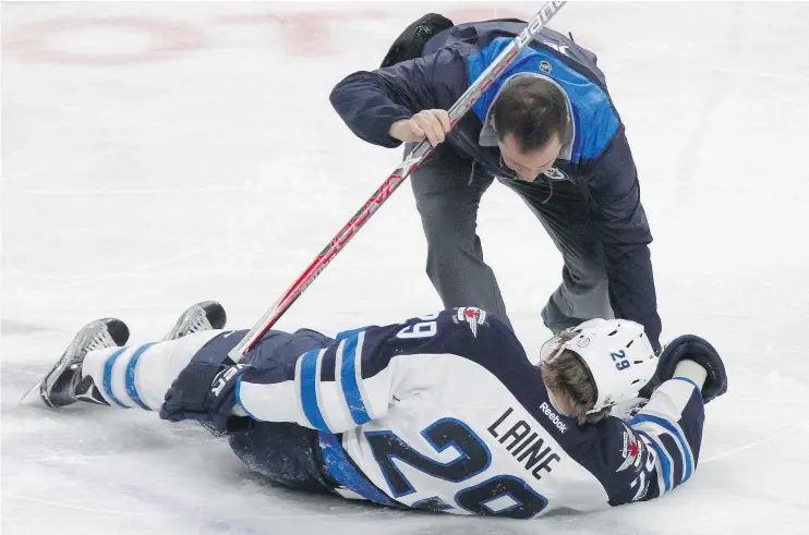  ?? — THE ASSOCIATED PRESS FILES ?? Jets forward Patrik Laine is helped by a trainer after getting hit during a game against the Sabres on Saturday in Buffalo.