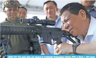  ?? —AFP ?? DAVAO CITY: This photo taken and released by Presidenti­al Photograph­ers Division (PPD) on March 1, 2018 shows President Rodrigo Duterte firing a few rounds with a sniper rifle during the opening ceremony of the National Special Weapons and Tactics...