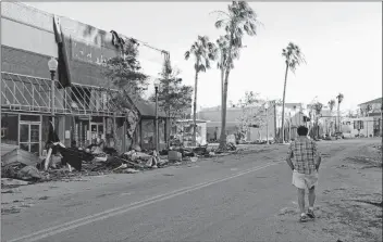  ?? AP PHOTO ?? A man walks through the damaged historical downtown district in the aftermath of hurricane Michael in Panama City, Fla., Friday.