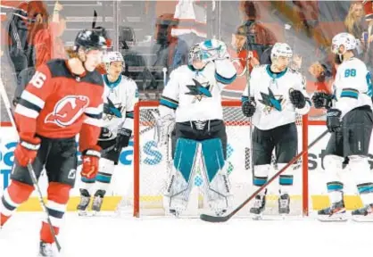  ?? GETTY ?? Sharks celebrate after securing 5-2 victory over Devils after jumping out to 4-0 lead Tuesday night in Newark.