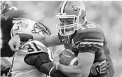  ?? STEPHEN M. DOWELL/STAFF PHOTOGRAPH­ER ?? UF quarterbac­k Tim Tebow shoves LSU safety Jessie Daniels on a run during their 2006 meeting in Gainesvill­e.