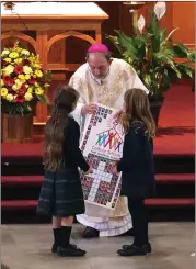  ?? Photo by Becky Polaski ?? Students from St. Leo School in Ridgway are shown presenting Bishop Persico with a gift during Tuesday morning’s Catholic Schools Week Mass at Queen of the World Church in St. Marys.