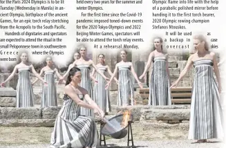  ?? PHOTO BY ARIS MESSINIS/AFP ?? GETTING READY
Greek actress Mary Mina, playing the role of the High Priestess, lights the torch during the rehearsal of the flame lighting ceremony for the Paris 2024 Olympics Games at the ancient temple of Hera on the Olympia archeologi­cal site, birthplace of the ancient Olympics in southern Greece, on Monday, April 15, 2024.