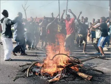  ?? PICTURE: PATRICK MTOLO ?? UP IN ARMS: Residents of KwaMakhuth­a protest over a planned taxi fare increase earlier this week, barricadin­g the main road in the township and burning tyres. Taxi have since resumed operations, with talks planned for today to tackle the dispute.