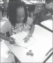  ??  ?? Math facts: Malaysia Bullock practices her math facts using a fidget spinner. Malaysia is in Nancy Beene’s second grade class at Yocum.