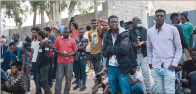  ?? ?? Migrants wait outside the United Nations High Commission­er for Refugees (UNHCR) negotiatio­n office in Tripoli, yesterday.