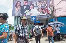  ??  ?? This picture shows people walking by the Thwin cinema in downtown area of Yangon. — AFP photos