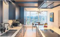  ?? NICK KOZAK FOR THE TORONTO STAR ?? NOW: A modern ceiling detail incorporat­es a range hood in the couple’s new kitchen, allowing the view to dominate.