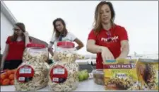  ?? ROSS D. FRANKLIN — THE ASSOCIATED PRESS ?? Jenn Gray, right, Ciara Schmalfeld, center, and Jessica Amstutz, left, help set up a special food table at the South Phoenix Missionary Baptist Church for kids affected by the Arizona teacher strike Thursday in Phoenix. Teachers in Arizona and Colorado...