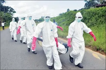  ??  ?? Burial team in protective gear carry a body of woman suspected to have died from Ebola virus in Monrovia, Liberia, Oct
18. (AP) MADRID, Oct 19, (AFP): Doctor Lago was with her kids, Doctor Fernandez was at Pilates class and Doctors Arsuaga and De la...