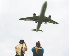  ?? KEVIN LAMARQUE
/ REUTERS FILES ?? Southwest Airlines flight attendants Krissy Stryker and Annette Santiago photograph a plane landing at Reagan
National Airport during the coronaviru­s crisis.