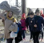  ?? BORIS GRDANOSKI/THE ASSOCIATED PRESS ?? Middle Eastern migrants and refugees walk towards the border with Serbia, after arriving at the transit centre for refugees near the village of Tabanovce, in northern Macedonia, Thursday.