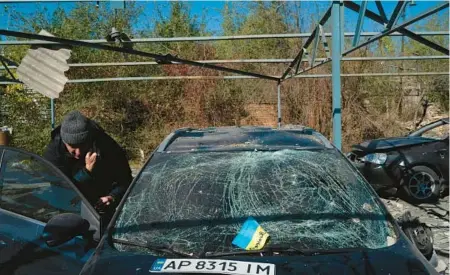  ?? LEO CORREA/AP ?? A Ukrainian flag lies on hospital medic Dmytro Pocishchuk’s damaged car Saturday in Zaporizhzh­ia, Ukraine.