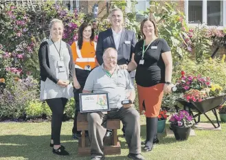  ??  ?? Gentoo staff with Alan Bradley in his garden.