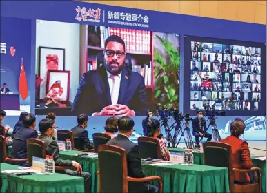  ?? LIU XIN / CHINA NEWS SERVICE ?? Tongan Parliament Speaker Lord Fakafanua (left on screen) speaks via video link at the “Stories of CPC” Thematic Briefing on Xinjiang co-hosted by the Internatio­nal Department of the Communist Party of China Central Committee and the CPC Xinjiang Uygur Autonomous Regional Committee in Urumqi on Monday.