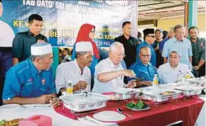  ?? AMRAN HAMID
PIC BY ?? Prime Minister Datuk Seri Najib Razak and Kedah Menteri Besar Datuk Seri Ahmad Bashah Md Hanipah (seated, right) enjoying a meal at the Gulai Ikan Meletup stall in Alor Star yesterday.