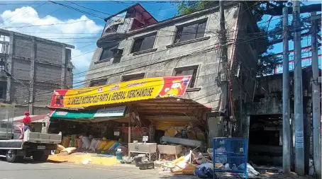  ?? AP ?? A damaged building lies on its side after a strong quake hit northern Philippine­s. At least five people were reported killed and over 100 others others injured.