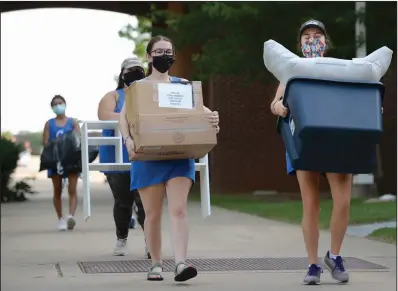  ?? (NWA Democrat-Gazette/Andy Shupe) ?? Volunteers help first-year University of Arkansas students and their families move into dormitory rooms Thursday on the campus in Fayettevil­le.