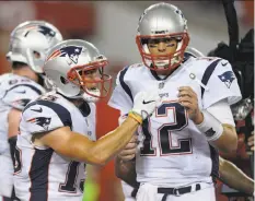  ?? Jason Behnken / Associated Press ?? New England receiver Chris Hogan (left) celebrates a touchdown reception from quarterbac­k Tom Brady during the first half.