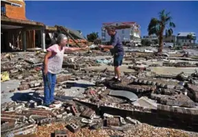  ?? (AFP) ?? TRAGEDIA. En México Beach una pareja recorre el lugar donde estaba su casa, arrasada por la furia de Michael.